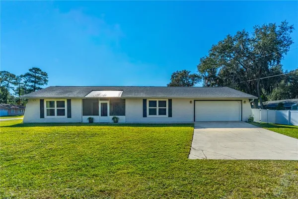 a front view of house with yard and trees