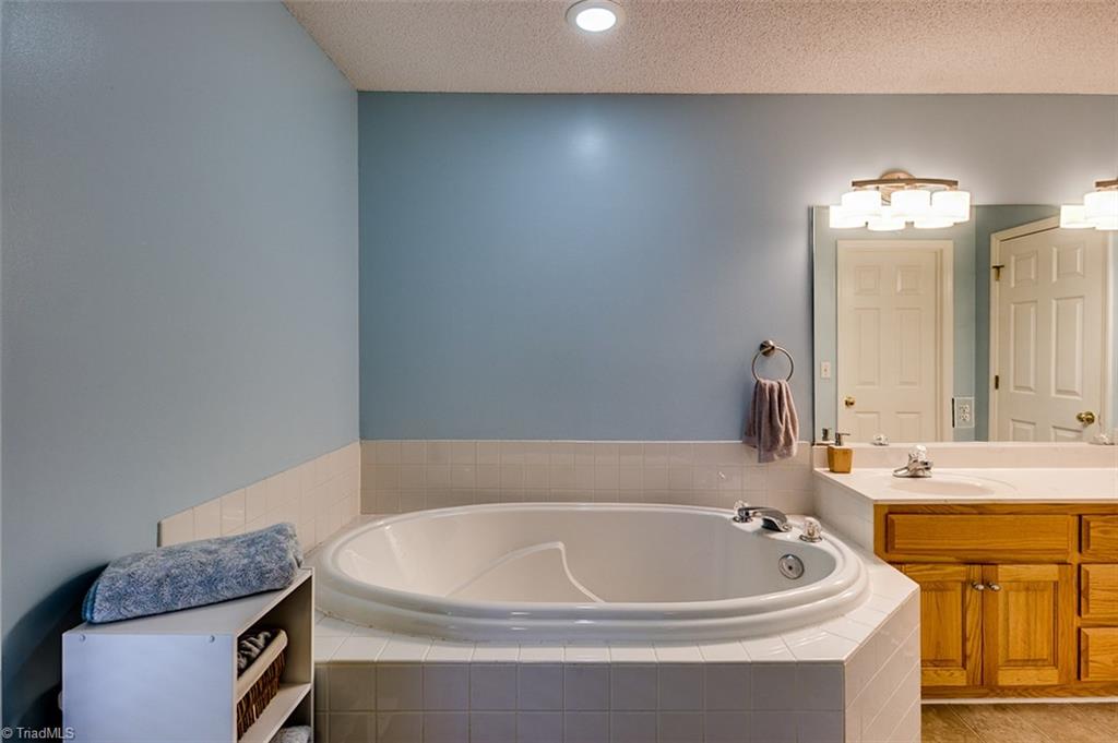 5553 Woodstream Road Randleman, NC 27317 - Photo 17 of 30 Master bath with new light fixtures and vinyl flooring, separate shower and double vanity