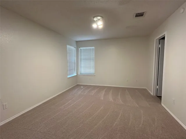 an empty room with windows and fan