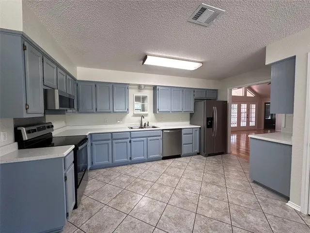 a kitchen with granite countertop a stove a microwave and a counter top space