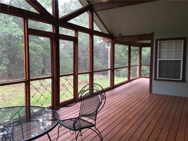 an empty room with windows and chandelier fan