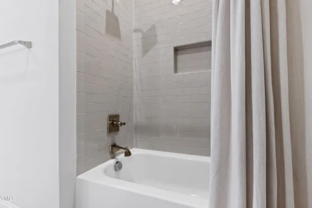 a white bath tub sitting next to a shower