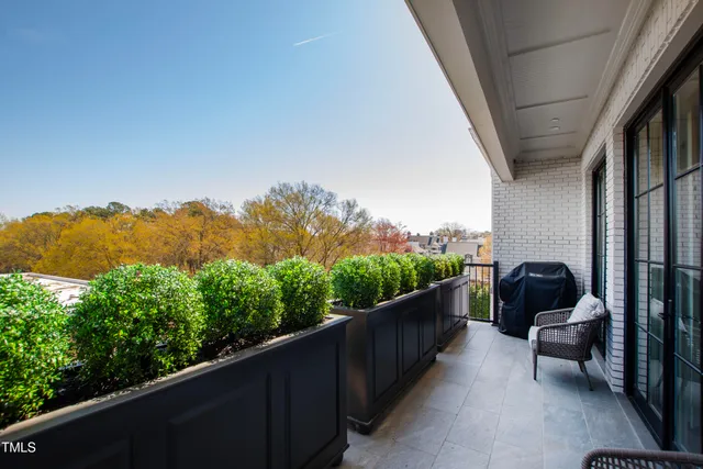 a balcony with wooden floor and outdoor seating