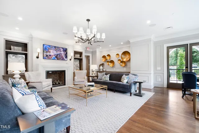 a living room with furniture a fireplace and a chandelier