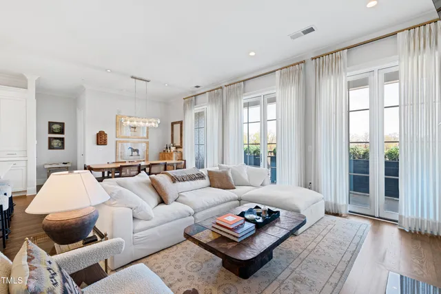 a living room with furniture a large window and a wooden floor