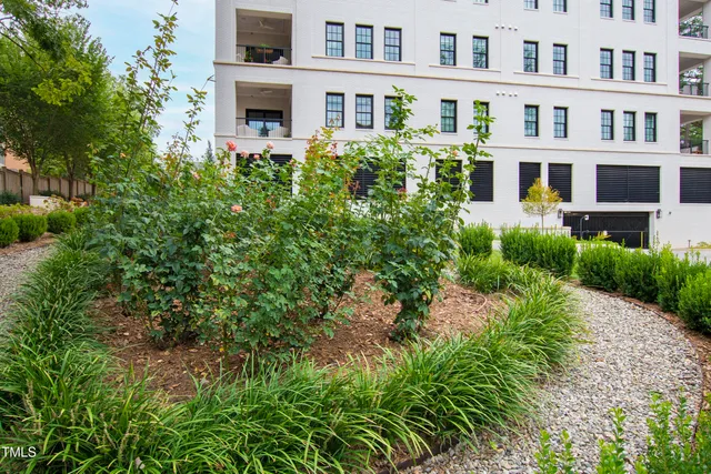 a front view of multi story residential apartment building with a yard