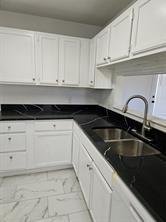 807 Wind Brooke Drive Arlington, TX 76001 - Photo 3 of 13 a kitchen with granite countertop white cabinets and sink