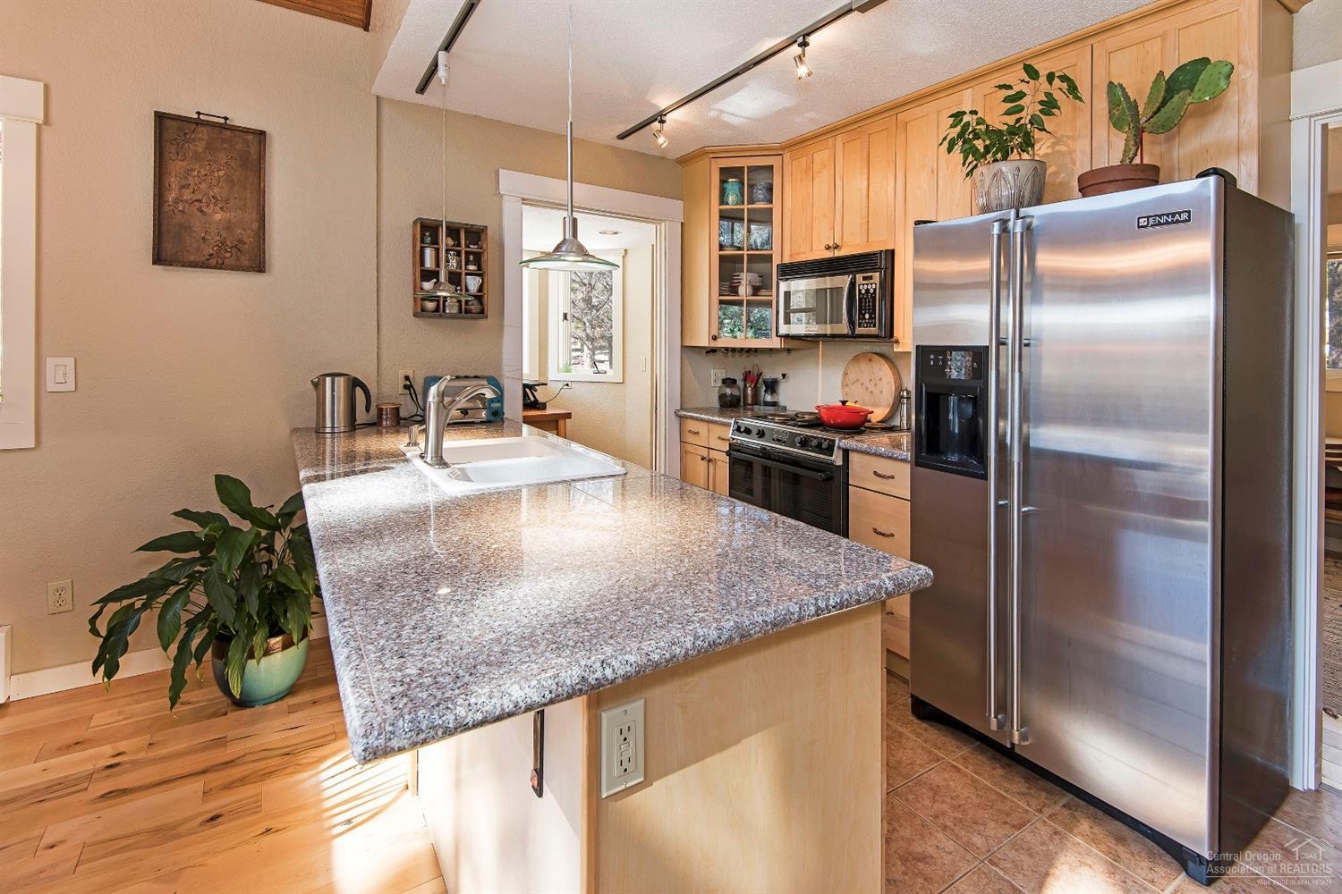 16033 Cattle Drive Road Sisters, OR 97759 - Photo 7 of 22 a kitchen with stainless steel appliances granite countertop a sink a refrigerator and a counter space