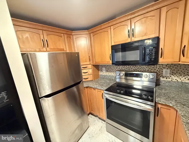 a kitchen with stainless steel appliances granite countertop a sink stove and microwave
