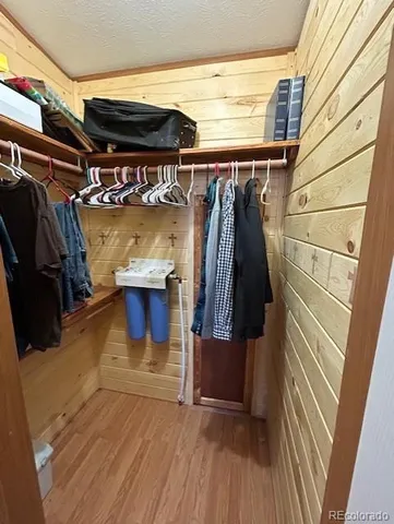 a view of walk in closet with clothes and shoes