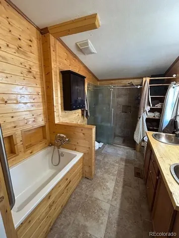 a bathroom with a sink a large mirror and a bathtub