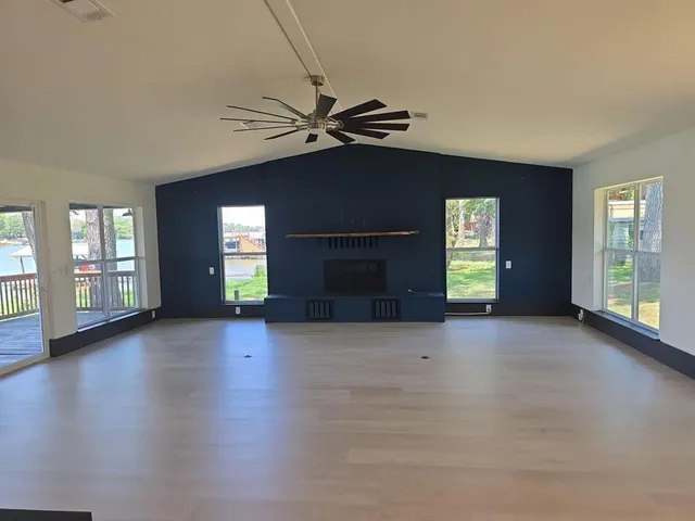 a view of a livingroom with a fireplace window and wooden floor