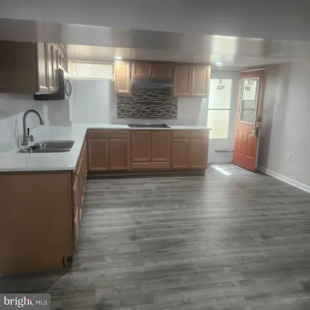 a kitchen with stainless steel appliances granite countertop a sink a stove and a wooden floors