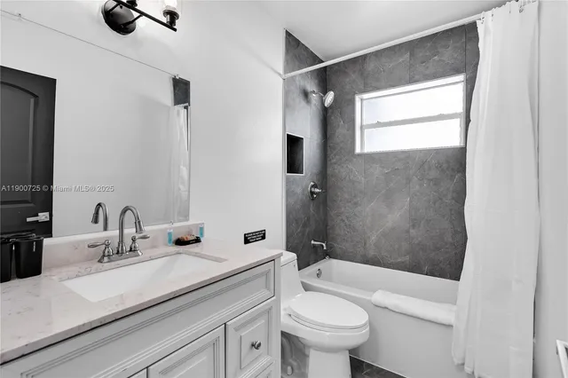 a bathroom with a sink a toilet a mirror and shower