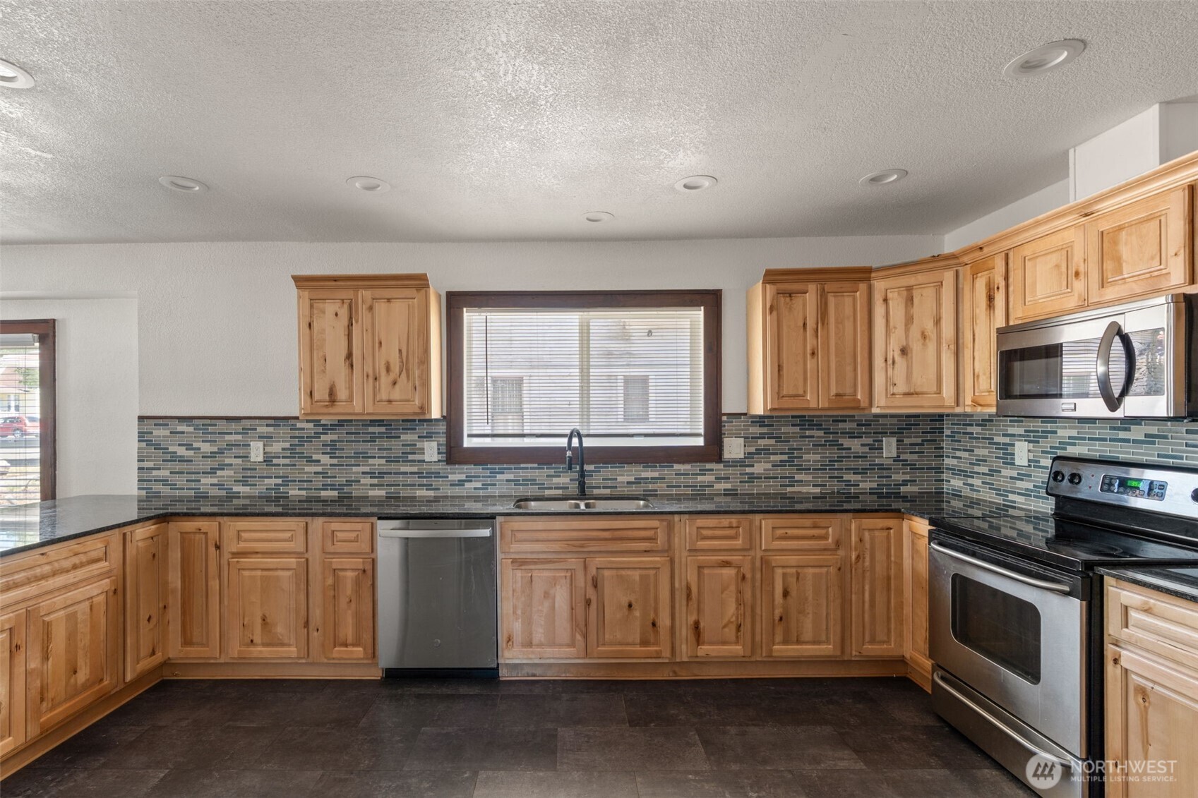 226 Southwest Lewis Street Chehalis, WA 98532 - Photo 14 of 27 a kitchen with stainless steel appliances granite countertop a stove a sink and a microwave