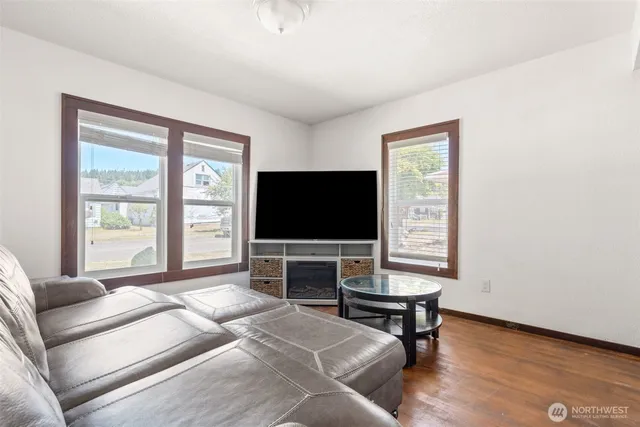 a living room with furniture and a wooden floor