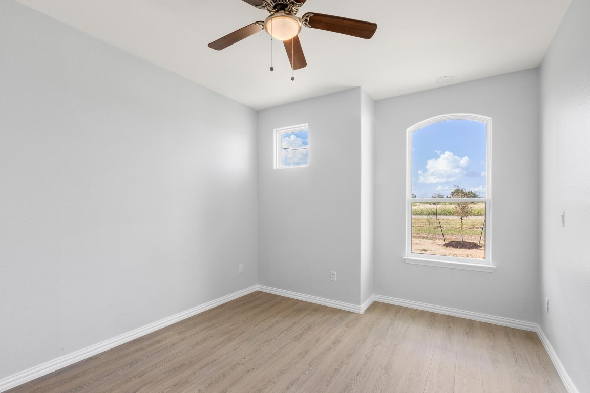 1136 County Road 484 Elgin, TX 78621 - Photo 25 of 37 Unfurnished room with light wood finished floors and a ceiling fan