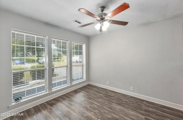 a view of a livingroom with a ceiling fan and window