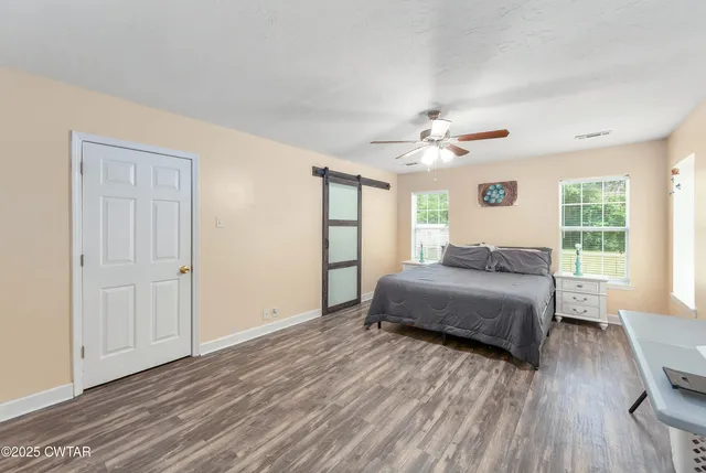 a bedroom with a large bed chandelier and a window