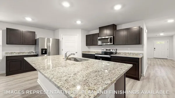 a kitchen with granite countertop a stove and a wooden floor