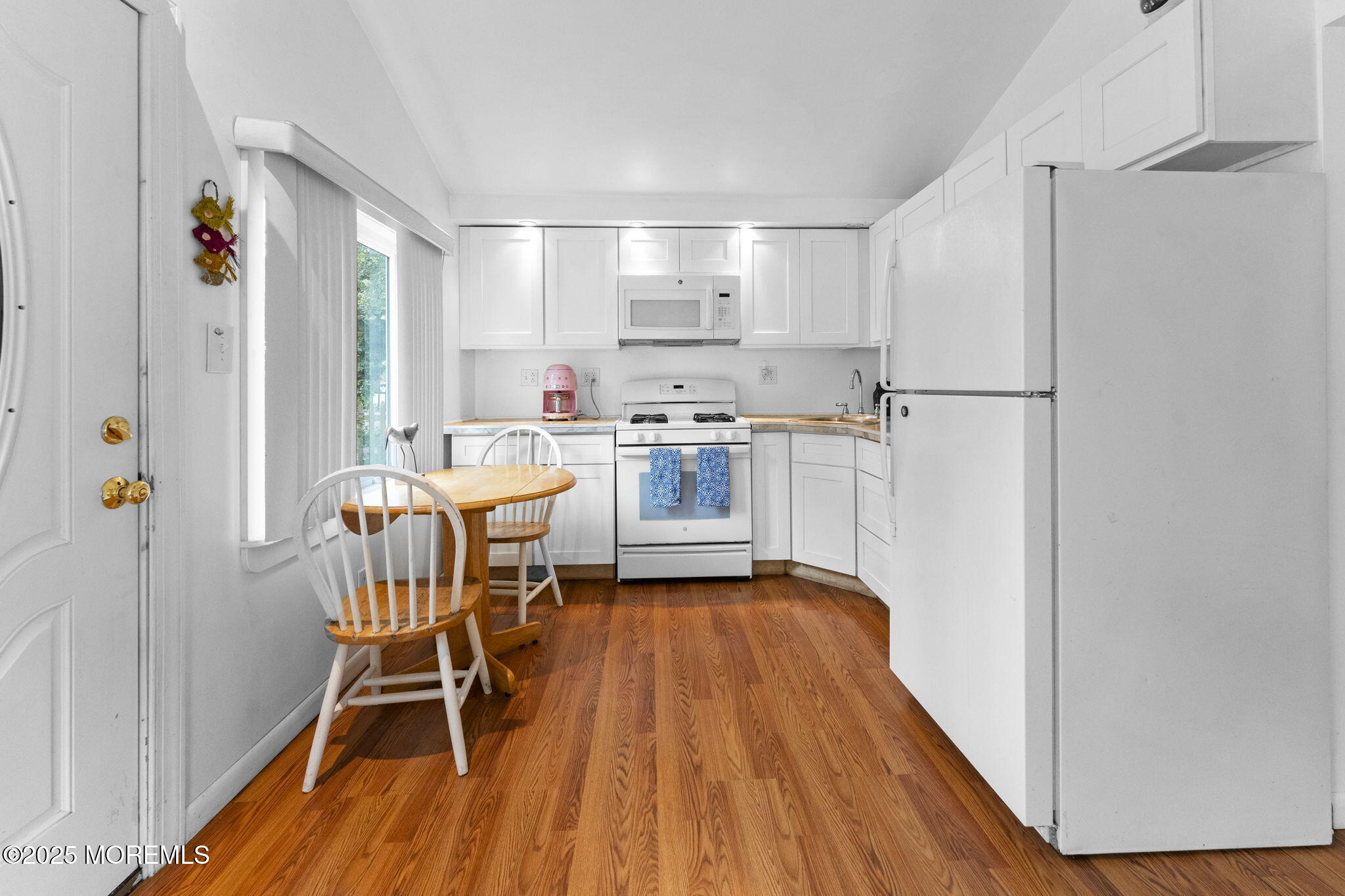 809 Beach Boulevard Forked River, NJ 08731 - Photo 8 of 16 a kitchen with a table chairs refrigerator and cabinets