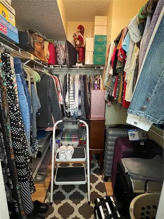 a view of walk in closet with clothes and shoes
