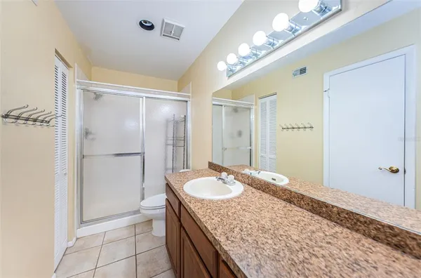 a bathroom with a granite countertop sink a mirror and a shower