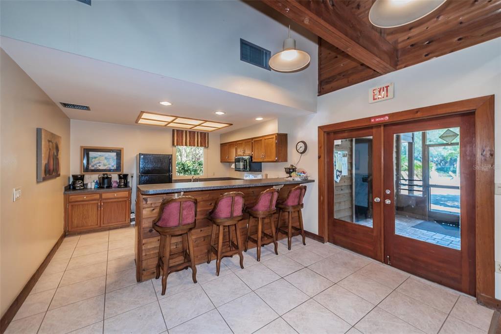 802 Lennox Road West, Unit 802 Palm Harbor, FL 34683 - Photo 33 of 42 a kitchen with stainless steel appliances kitchen island granite countertop a table and chairs in it