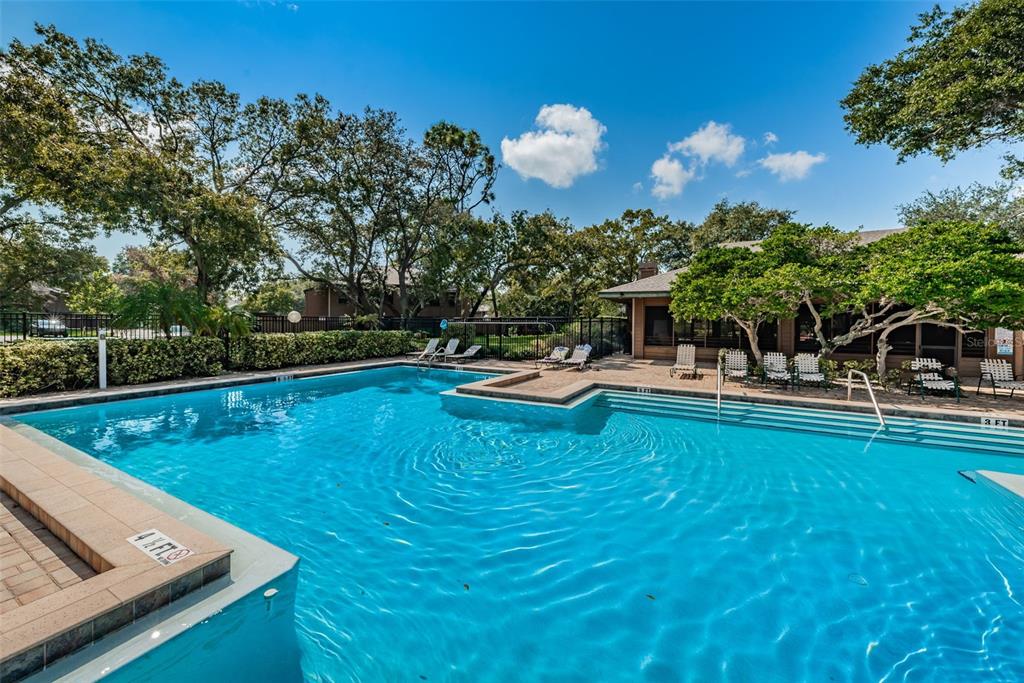 802 Lennox Road West, Unit 802 Palm Harbor, FL 34683 - Photo 38 of 42 a view of a swimming pool with a table and chairs