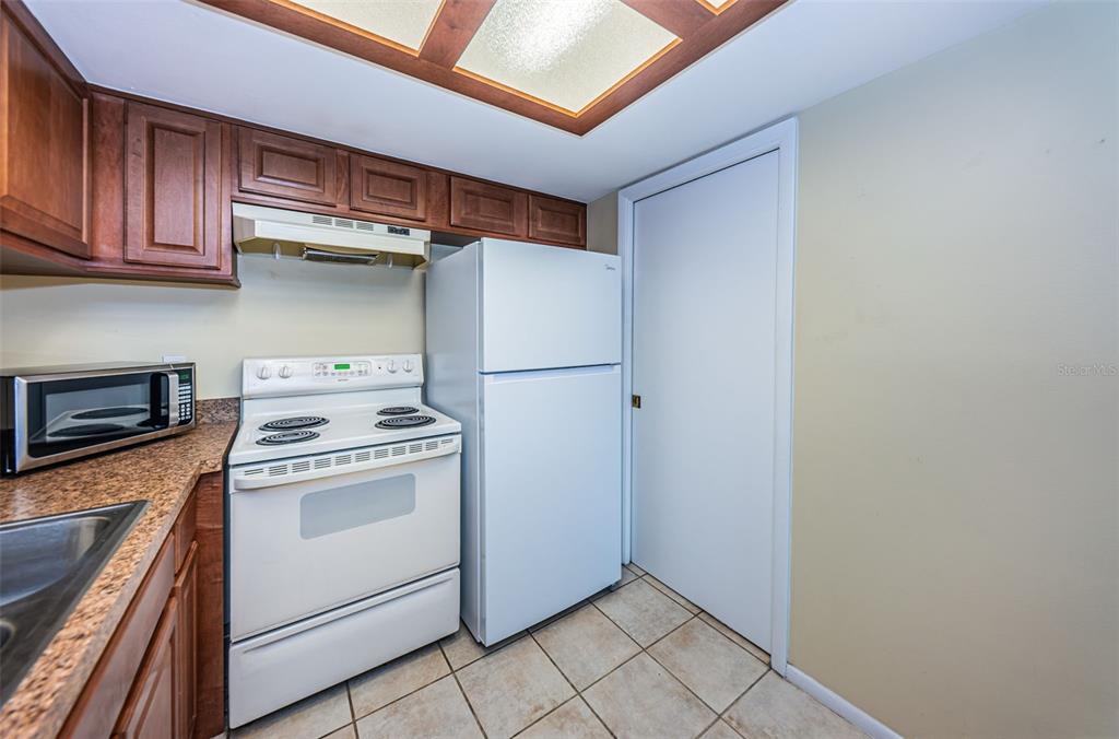 802 Lennox Road West, Unit 802 Palm Harbor, FL 34683 - Photo 10 of 42 a kitchen with a stove top oven and cabinets