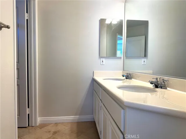 a bathroom with a double vanity sink and a mirror