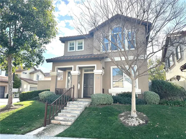 a front view of a house with a garden and plants