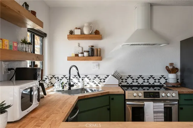 a kitchen with a sink stove and wooden floor