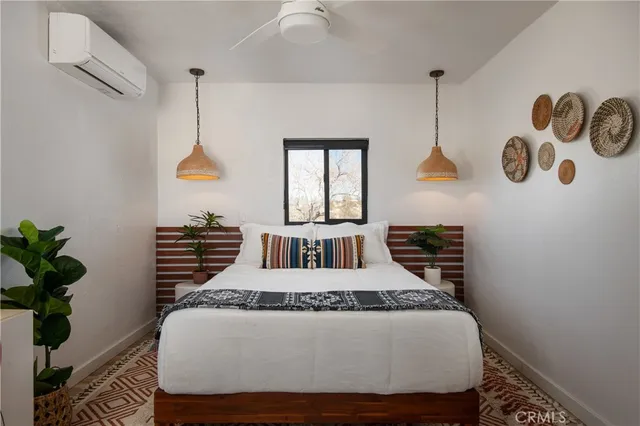 a large bed sitting in a bedroom next to a window and a chandelier