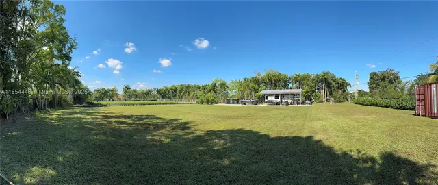 a view of a big yard with swimming pool and green space