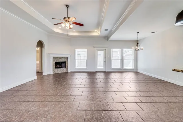 a view of an empty room with glass door and fan