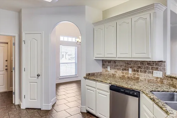 a kitchen with granite countertop white cabinets and sink