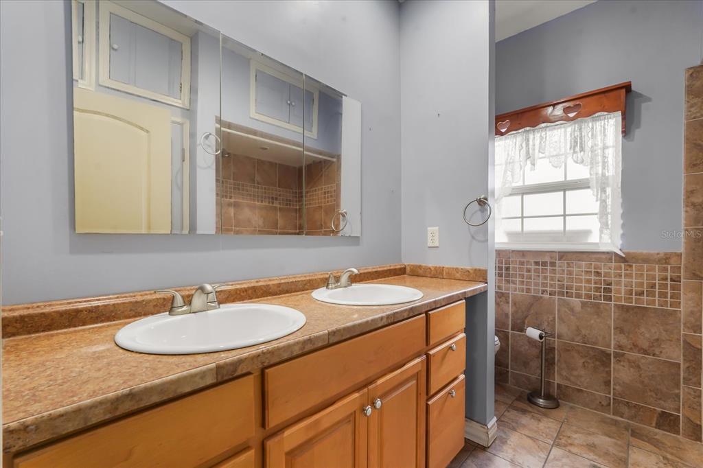 3303 Massee Road Davenport, FL 33837 - Photo 33 of 40 a bathroom with a sink toilet a mirror and vanity