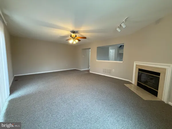 an empty room with windows and fireplace