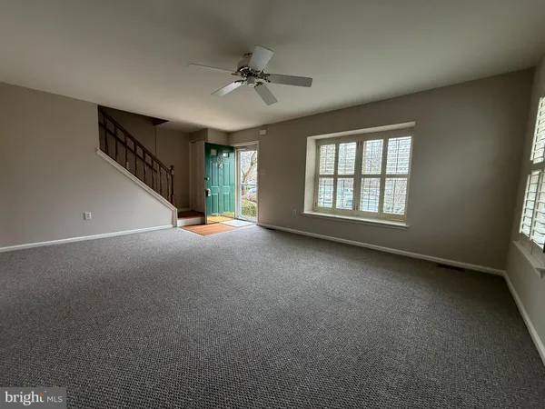 a view of a livingroom with a ceiling fan and window