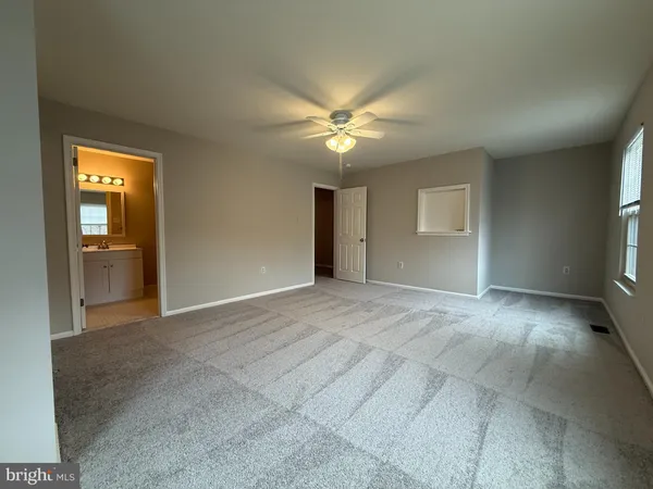 a view of a big room with windows and chandelier fan