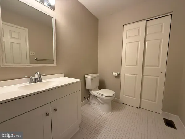 a bathroom with a toilet a sink a vanity and mirror