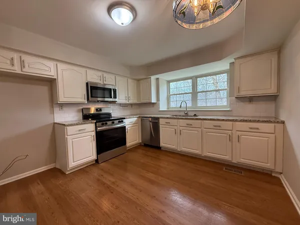a kitchen with sink a microwave and cabinets
