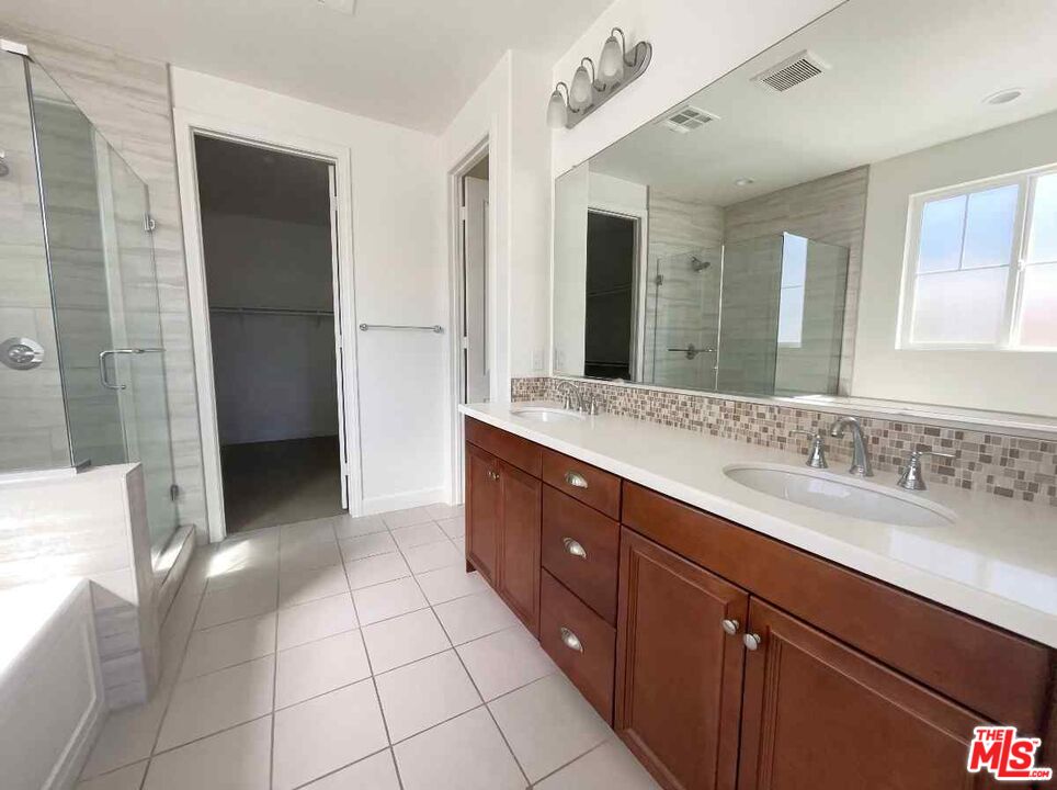 264 Rose Street Fillmore, CA 93015 - Photo 17 of 24 a spacious bathroom with a granite countertop sink a mirror and a shower