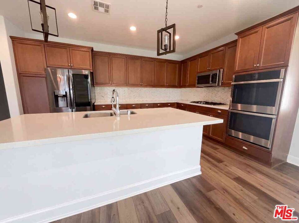 264 Rose Street Fillmore, CA 93015 - Photo 2 of 24 a kitchen with stainless steel appliances a sink a stove a microwave and wooden floors