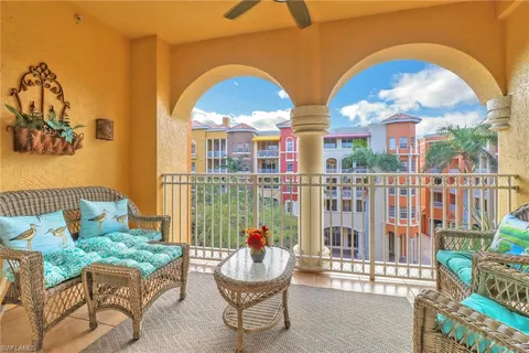 a view of a balcony with two chairs and a potted plant