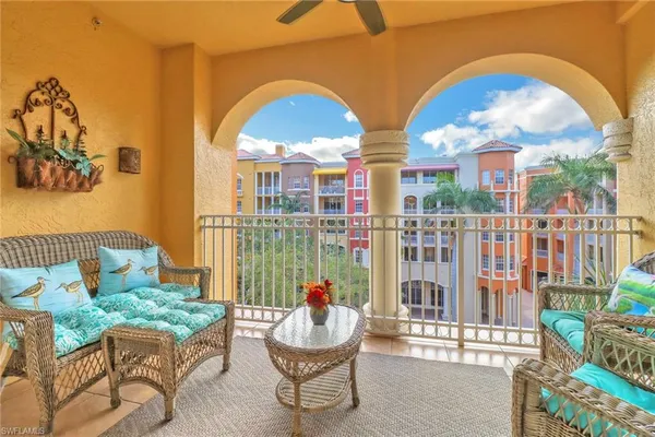 a view of a balcony with two chairs and a potted plant