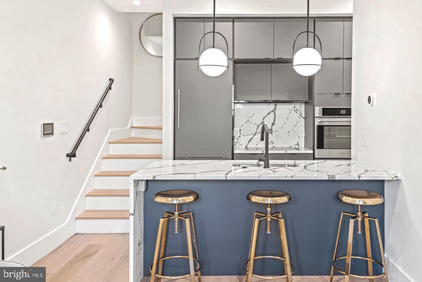1128 6th Street Northwest, Unit 3 Washington, DC 20001 - Photo 2 of 26 a kitchen with stainless steel appliances granite countertop furniture and a chandelier
