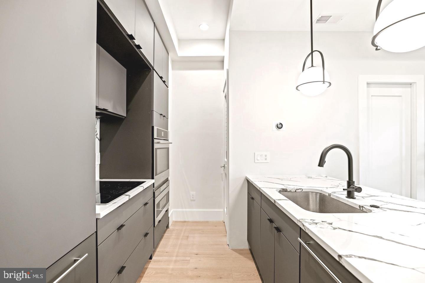 1128 6th Street Northwest, Unit 3 Washington, DC 20001 - Photo 8 of 26 a kitchen with a sink and a refrigerator