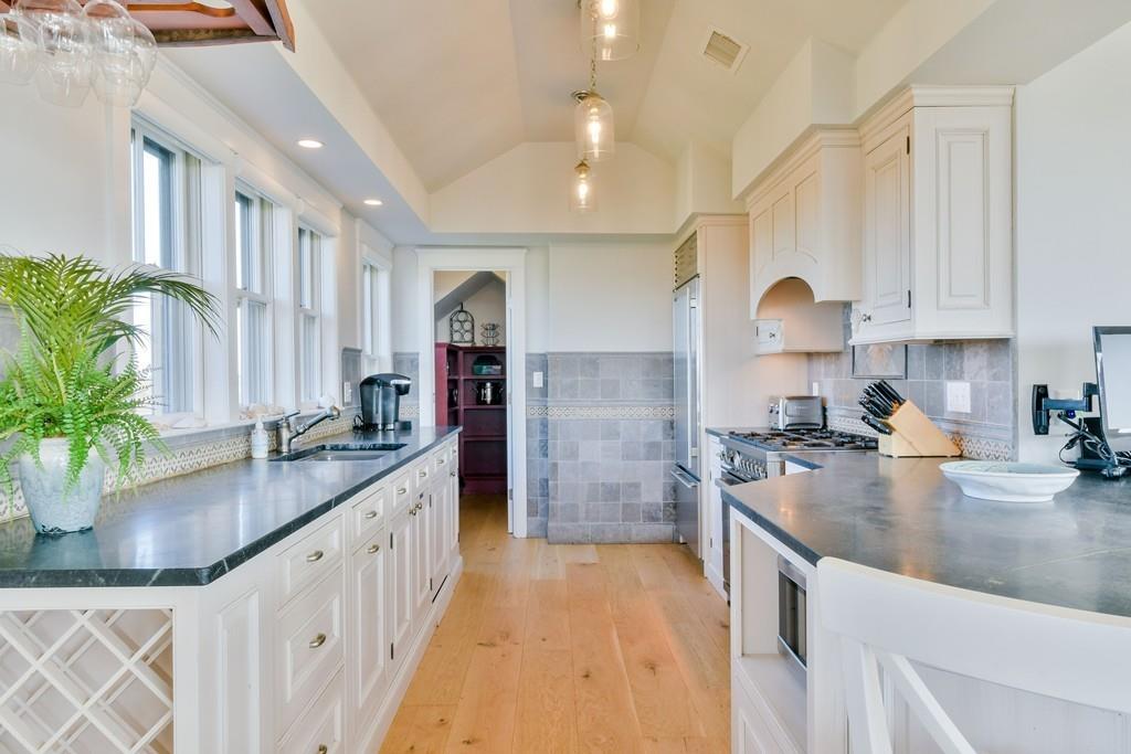 51 Madequecham Valley Road Nantucket, MA 02554 - Photo 7 of 25 a kitchen with kitchen island granite countertop a sink a counter top space and cabinets
